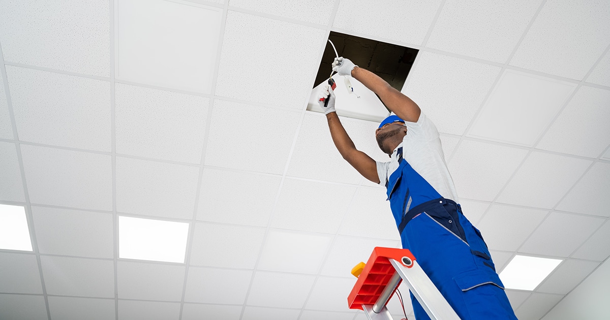 Worker repairing ceiling lighting