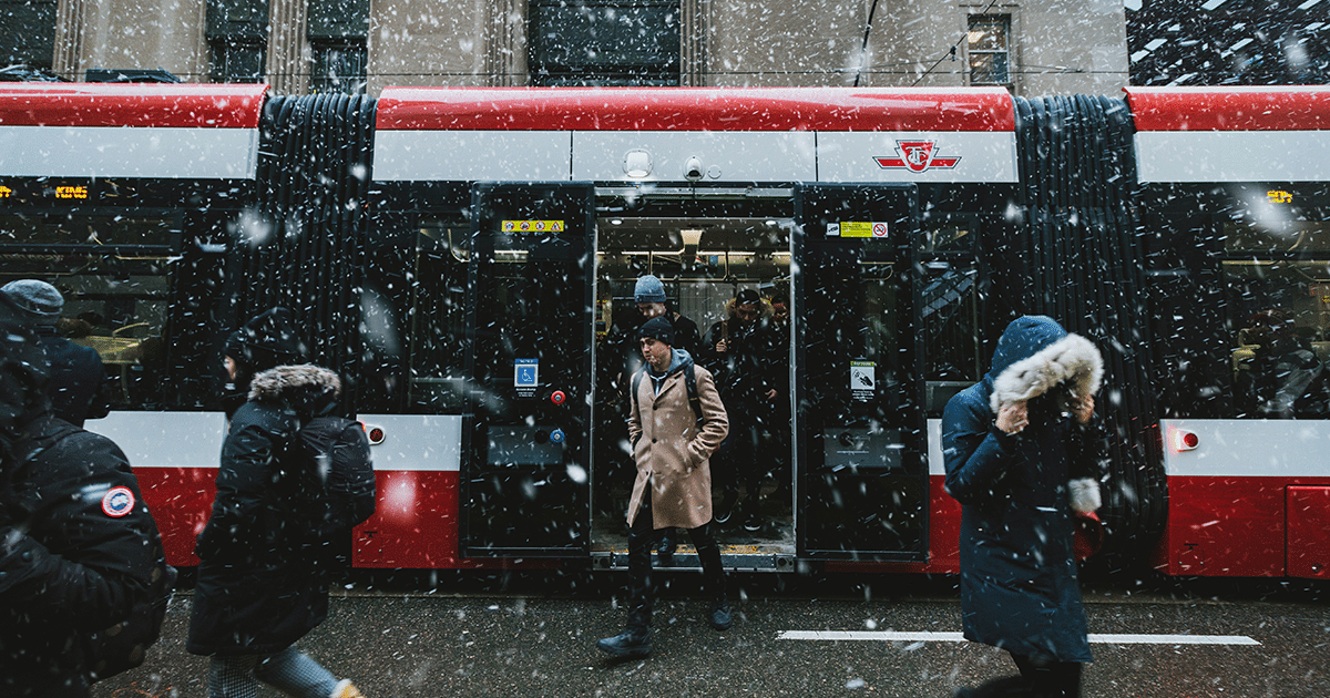 Mensen stappen uit tram in besneeuwde stad