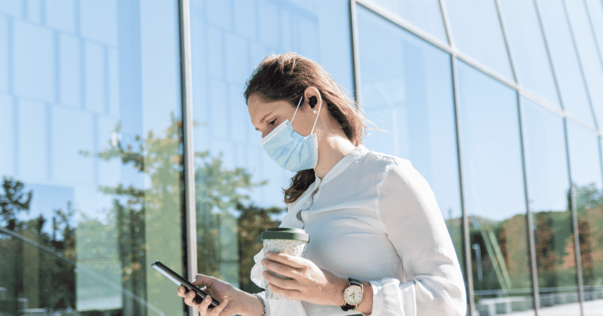 Woman wearing face mask checking her phone