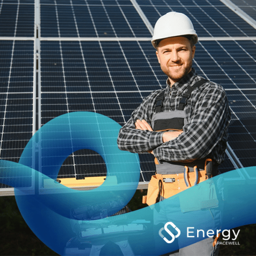 A person in a hard hat standing in front of solar panels